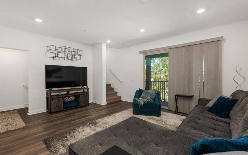 The living room is located on the second floor and features luxury vinyl flooring, lots natural light and access to a private patio.