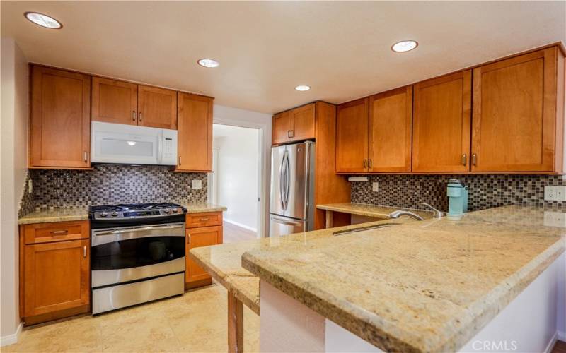 Remodeled kitchen with granite counters, newer appliances including gas stove top, refer, dishwasher and eating bar