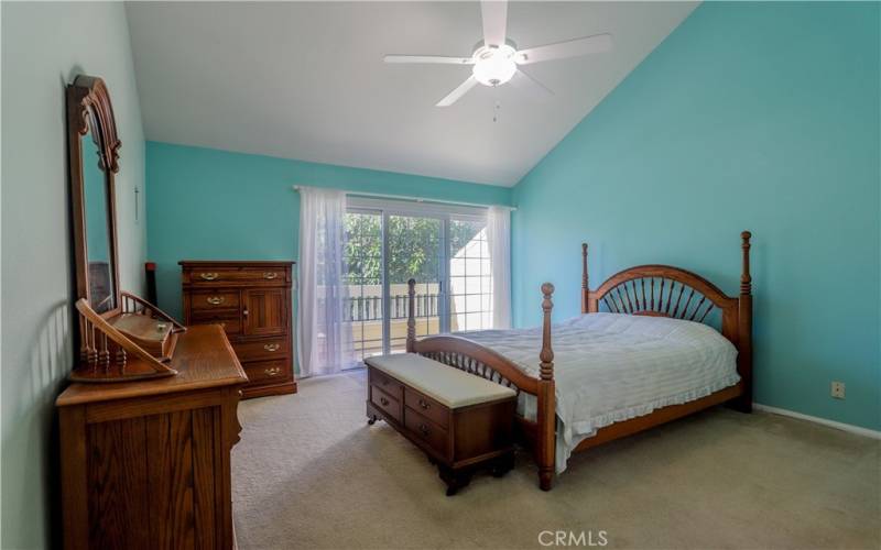 Primary room with high ceiling, balcony and greenbelt view.