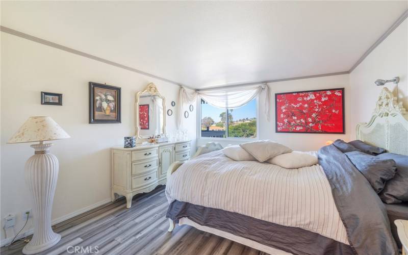 Tastefully furnished bedroom with views of the hills.