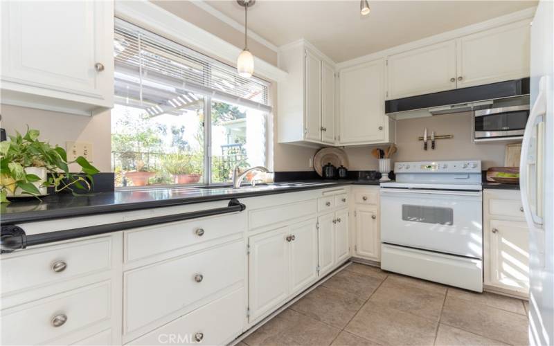 Crisp, white kitchen with black granite counters.