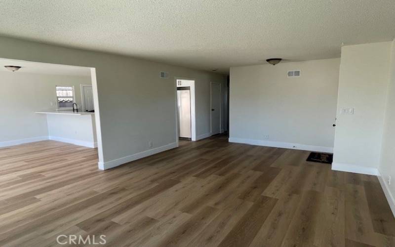 View of open living room into dining area, kitchen.