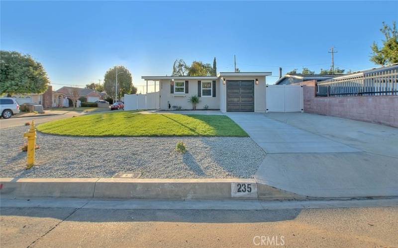 Front Yard; New Grass and Rock Landscape. Newly poured Driveway and Vinyl Fencing.