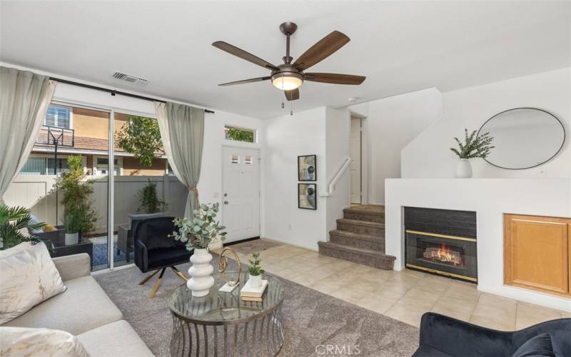 Comfortable living room with fireplace and modern ceiling fan, new carpet,  freshly painted light and bright throughout the home