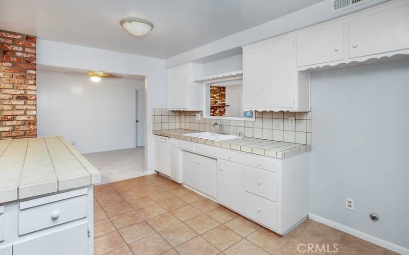 The cook in the family is going to truly appreciate the open and bright kitchen with its gleaming window, white cabinetry, handy pantry, tile countertops, dual basin sink, GE dishwasher and easy-care tile floors; plus, a convenient breakfast bar.