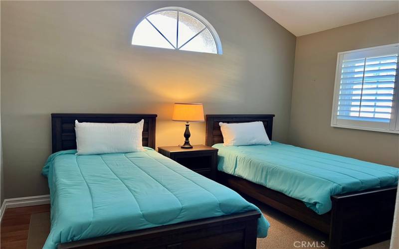 Bedroom #2 with vaulted ceilings, laminate flooring, plantation shutters and walk in closet!