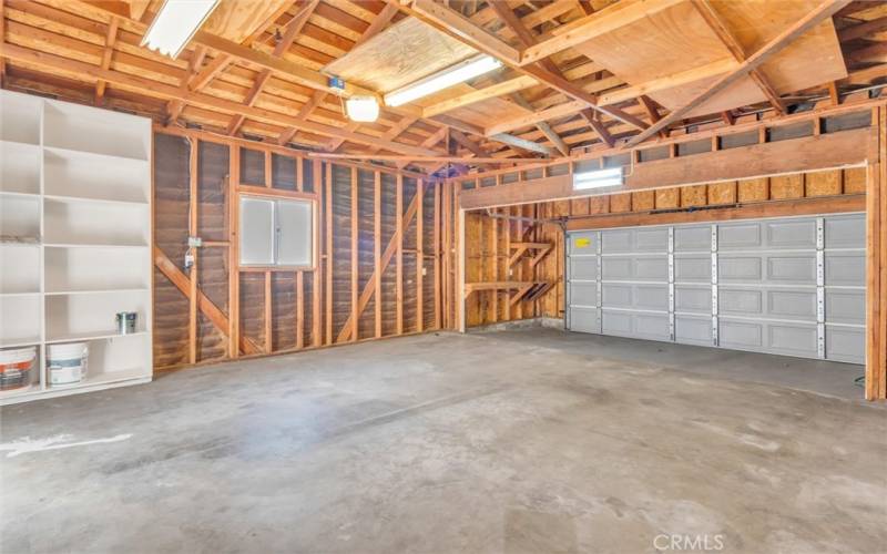 Interior of expanded garage with roll up garage door and garage door opener