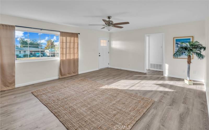 Another view of the spacious living room with Luxury Vinyl plank flooring