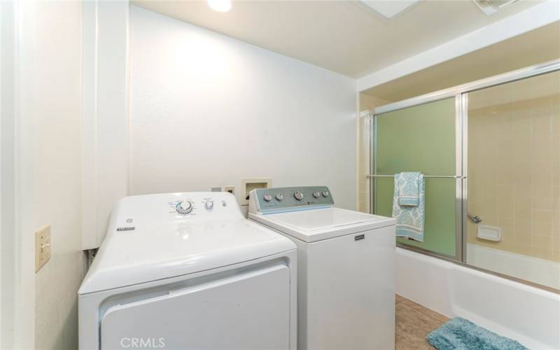 Full size washer and dryer in bathroom.