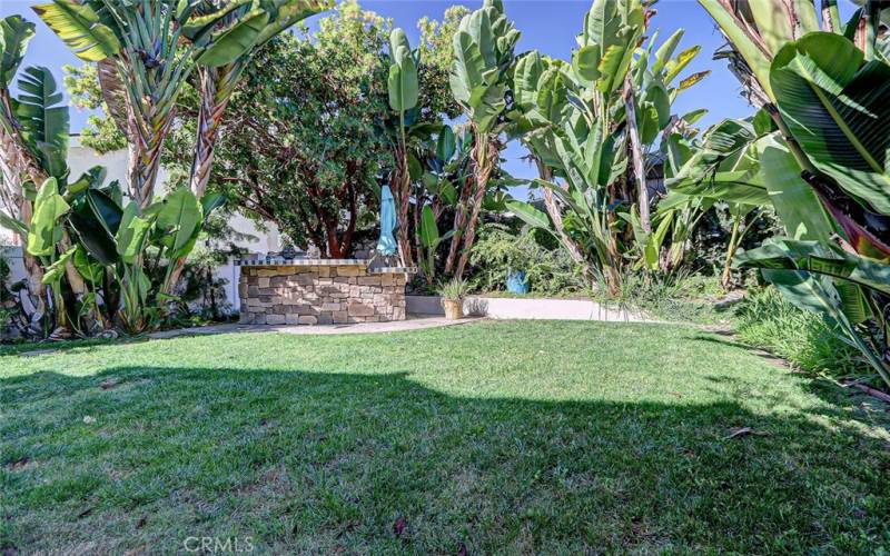 Grassy back yard with stone bar/outdoor kitchen!