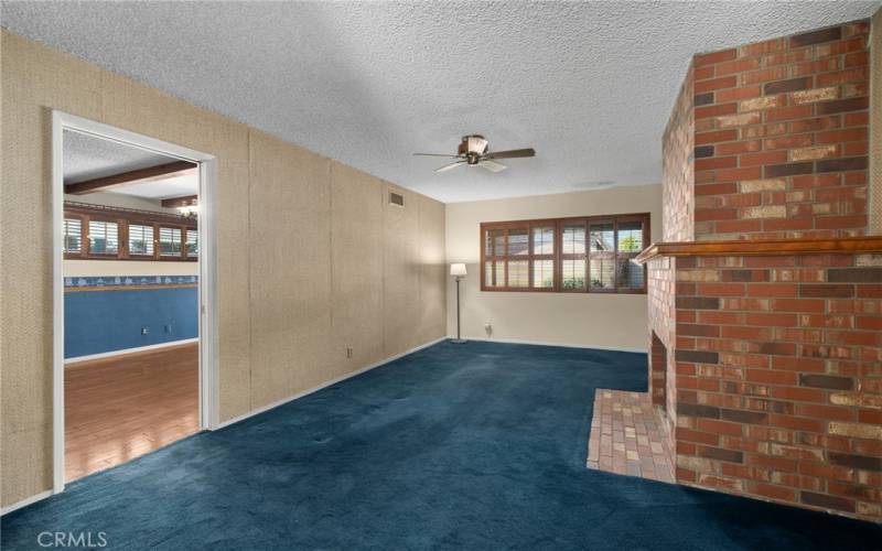 Living room with warm brick fireplace & mantel.