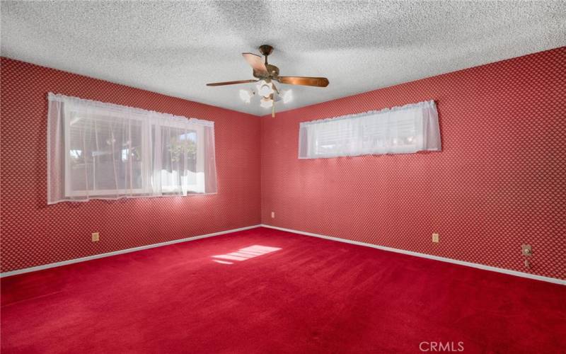 Primary bedroom with attached bathroom looks out onto the back yard.