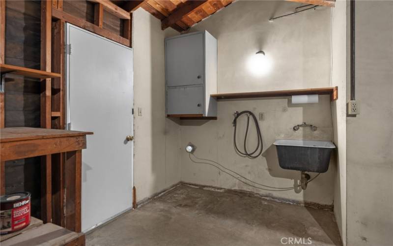 Laundry area inside the garage with door to exterior.