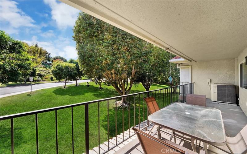 Private balcony with abundant space provides an area for relaxation and views of golf course surrounded by welcoming trees.