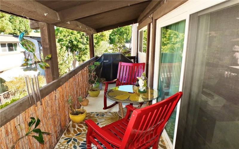 Large sliding door to the private Balcony off Living Area looking out to the trees and grounds out front