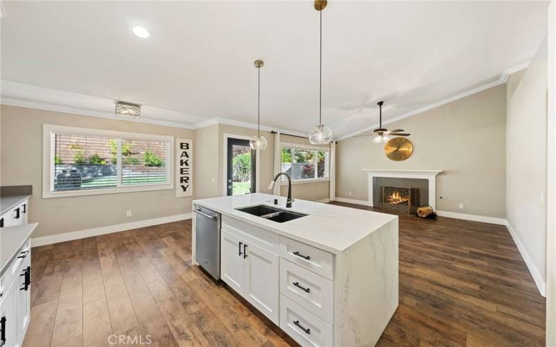 Beautiful kitchen Island with quartz countertop and stainless-steel dishwasher. open floorplan to the family room