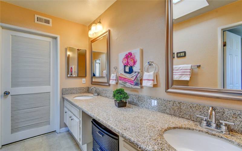 En-suite bathroom with vanity area in counter and door to walk-in closet