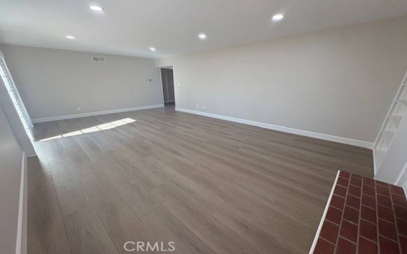 View of the living room from the end where the fireplace and bookshelves are located.