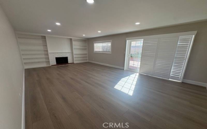 Large living room with wood burning fireplace and direct access to the covered patio area.