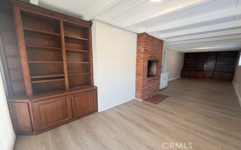 Family room with indoor BBQ, many bookshelves, direct access to the back patio and yard.