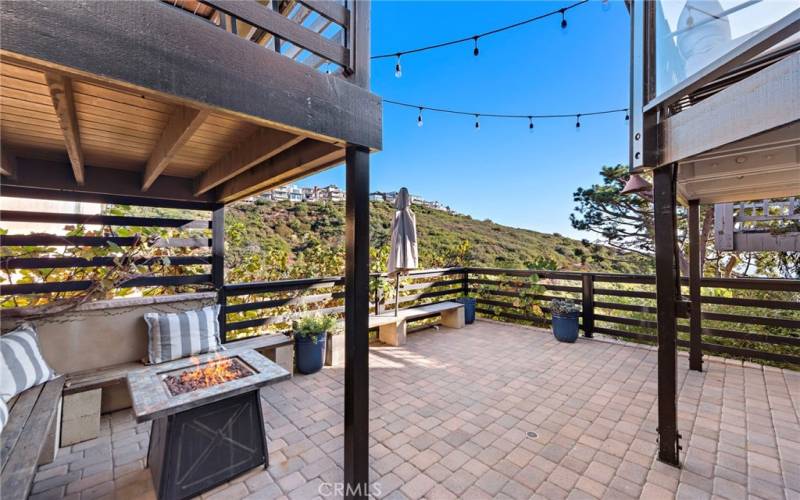 Lower covered rear patio area with fire pit and bench seating