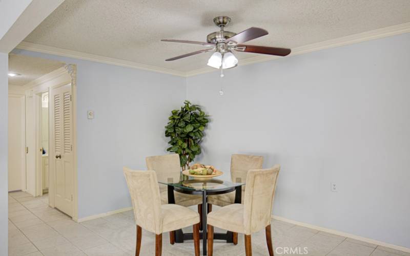 The dining room features a ceiling fan and crown molding.