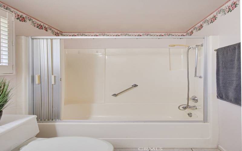 The primary bathroom features a tub with shower over the tub.