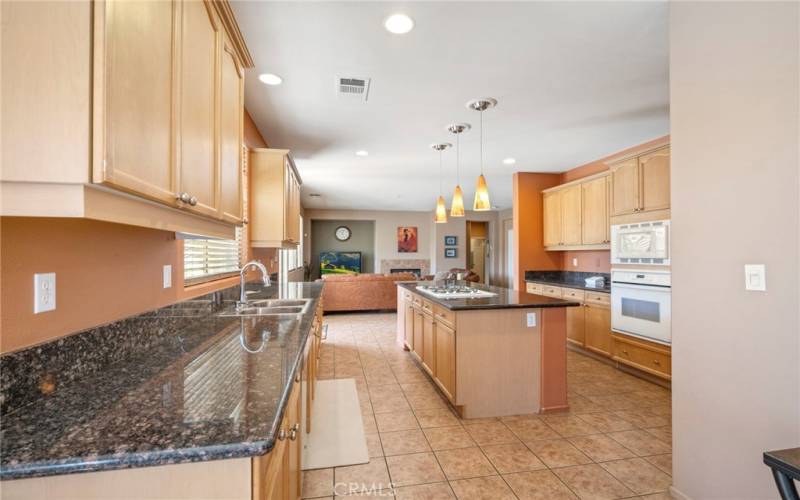 Open kitchen with granite counter tops, spacious island with gas range, plenty of cabinet space