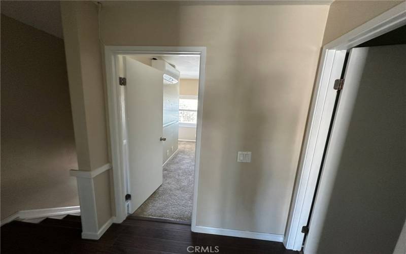 View from top of stairs. Primary bedroom straight ahead and full bathroom to the right