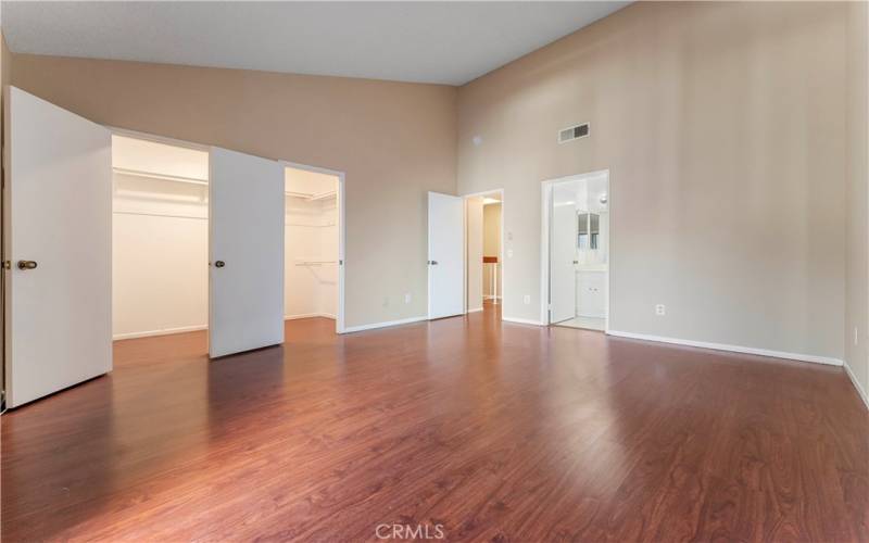 Master bedroom with wooden floors, balcony with large walk-in closet.