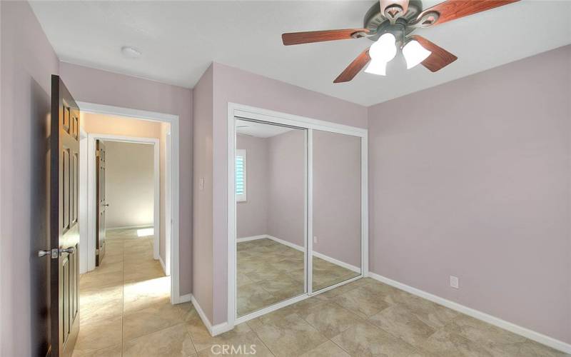 Another secondary bedroom, tile floors and ceiling fan.