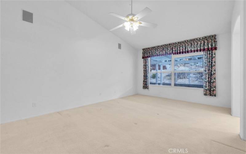 Master bedroom with custom drapes,  ceiling fan and built-in speakers