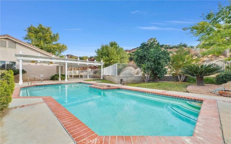 Pool with with view of foothills behind home