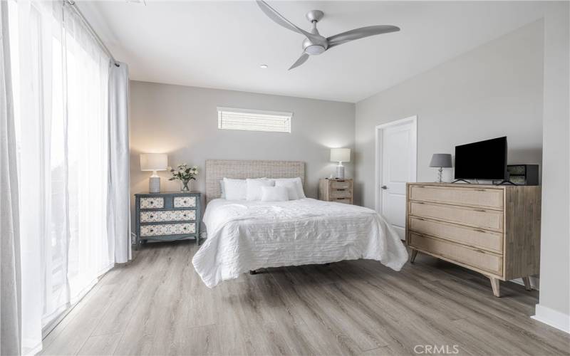 Primary suite w/walk-in closet & modern ceiling fan.