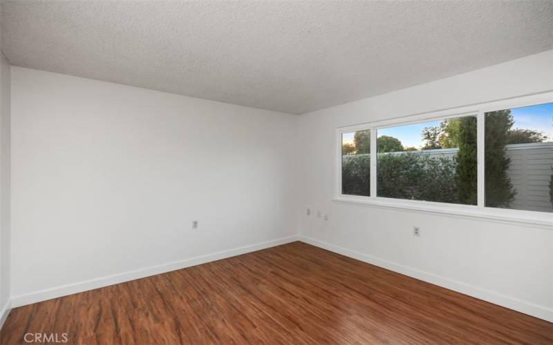 Main bedroom with laminate flooring, big window for letting light in and a large double closet has mirrored doors.