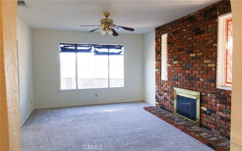 Formal living room with fire place, decor glass and ceiling fan