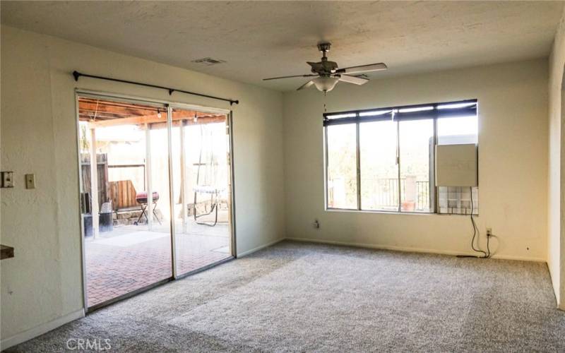 Formal family room with wide open windows , ceiling fan and French sliding  door