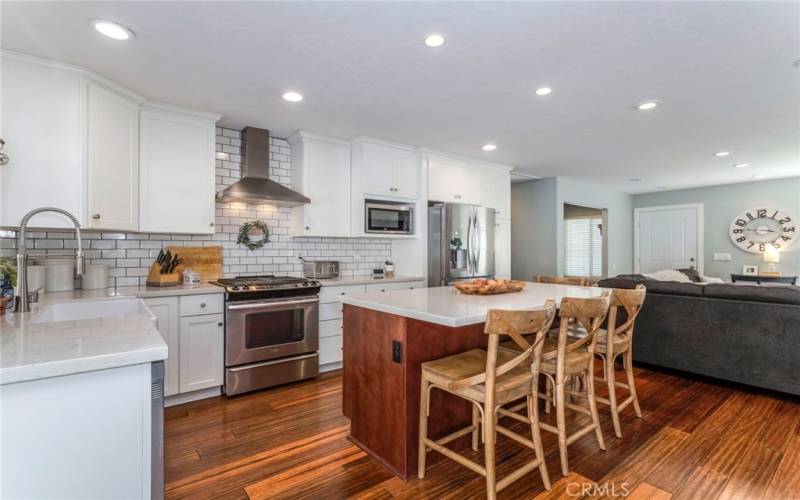 Kitchen with subway tiled wall, granite countertops and an island