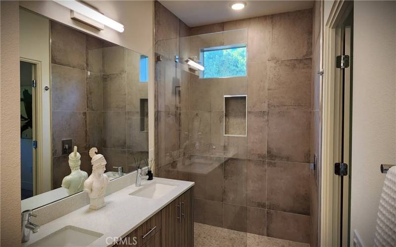 Double sink vanity with a large walk in shower in the primary bathroom.