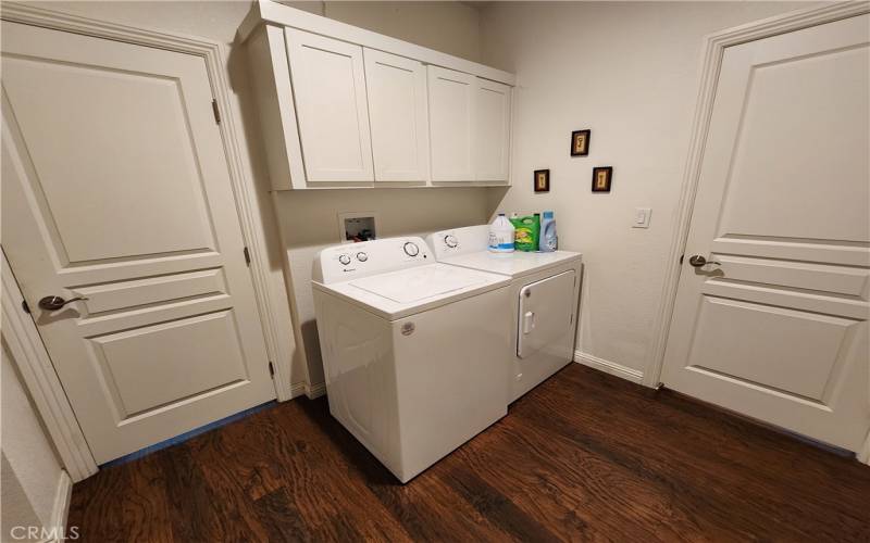 Laundry room with extra cabinets and broom closet