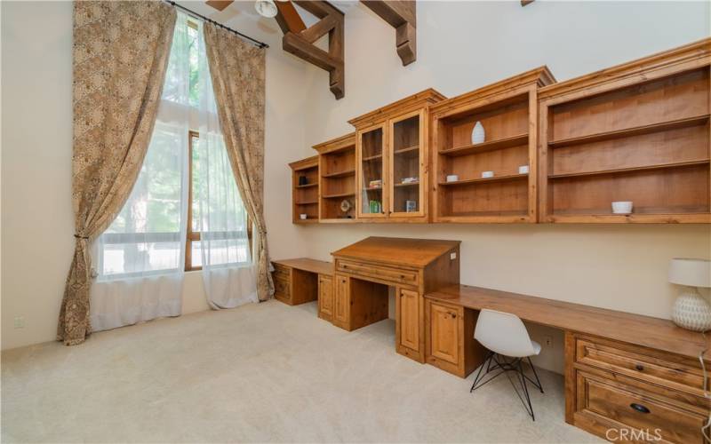 large office/study room with built in shelves and a separate door to the front yard