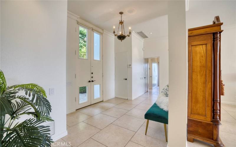 Grand double doors open to a warm, modern interior foyer.