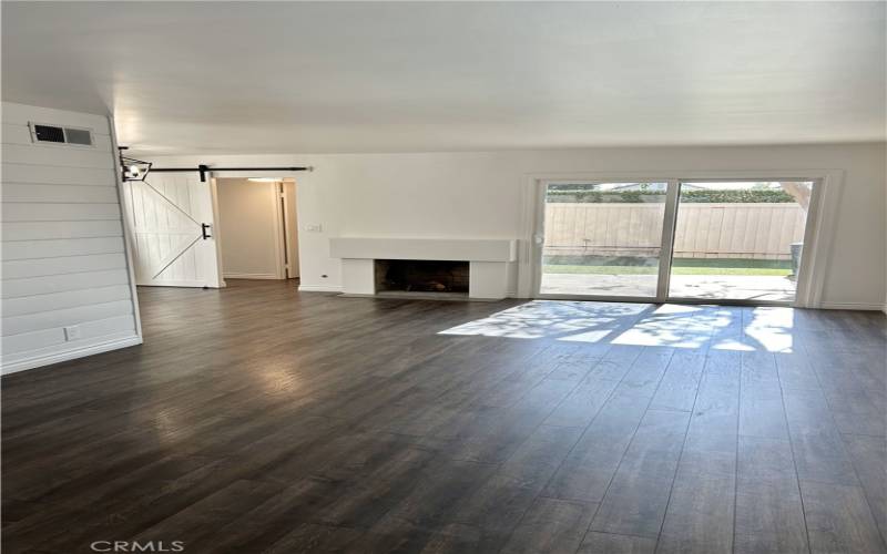 Laminate floor throughout with faux fireplace and sliding door in living/family room