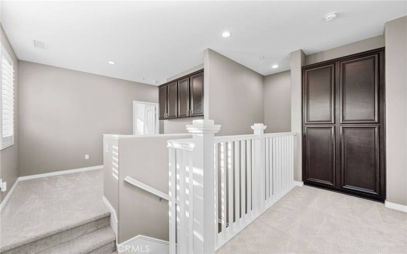 This photo shows the office area near the top of the stairs and then the linen cabinets on the primary bedroom wing of this fantastic floorpan.
