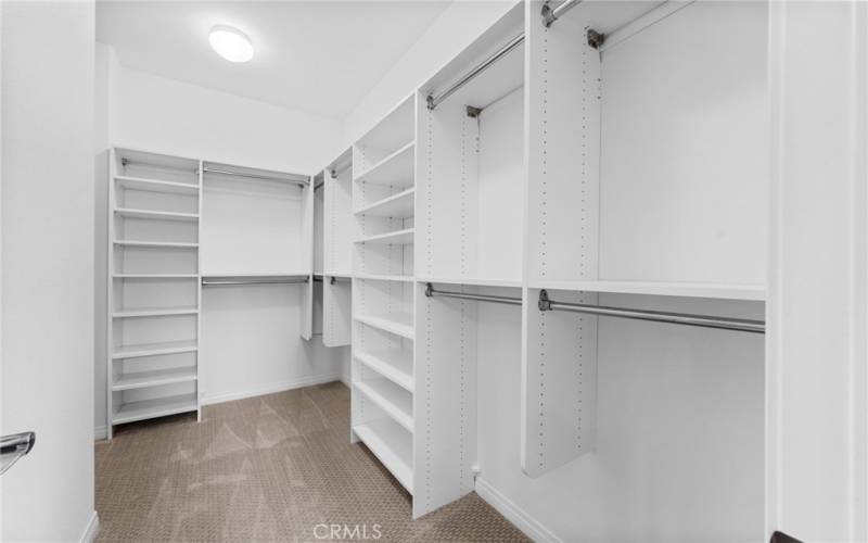 The large walk-in closet for the primary bedroom has excellent lighting, NEW custom washable paint and plush designer carpeting!