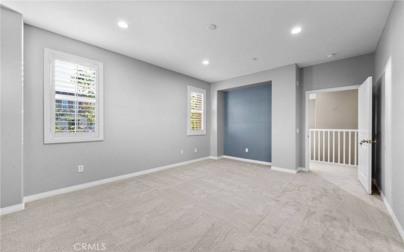 The primary bedroom features recessed LED lighting, an alcove for furniture/TV, multiple windows and custom paint.