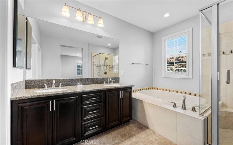 The primary bathroom features a generous walk-in shower, soaking tub, double vanity and tile flooring.