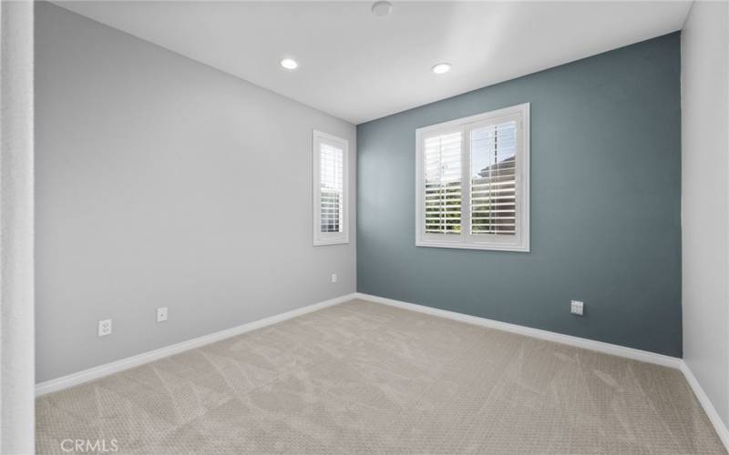 Secondary bedroom #1 with custom paint, luxury carpet and recessed LED lighting.