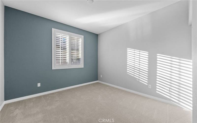 Secondary bedroom #1 with custom paint, luxury carpet and recessed LED lighting.