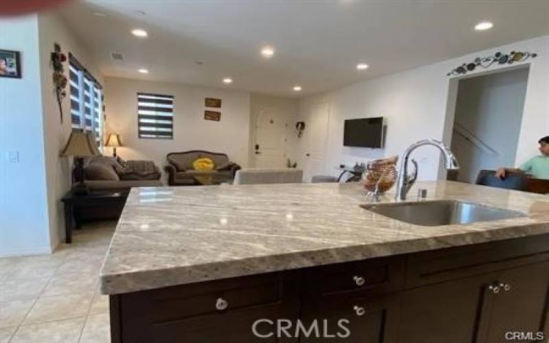 This is a view of the kitchen island from a different angle. It shows the sink, faucet, and disposal, as well as the countertop and cabinets.